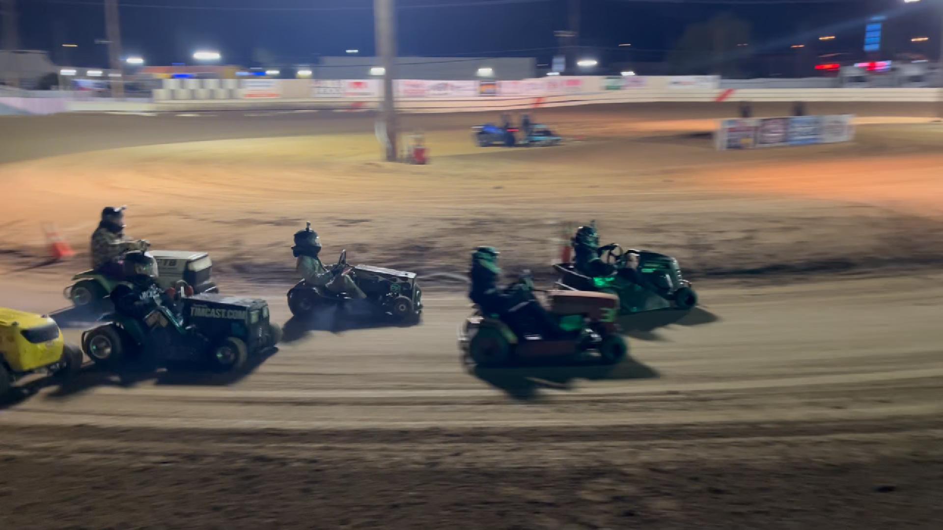 Lawnmower racers competing under the lights